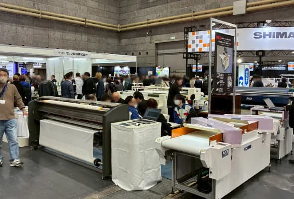 縫製関連機器が並び、多くの来場者が見学するASM OSAKAの会場。
